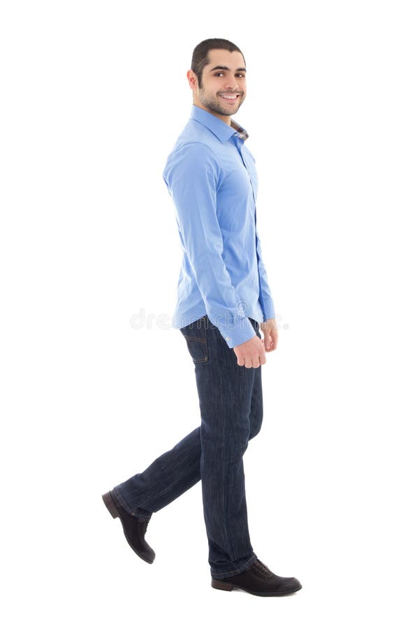 side view of young arabic bearded business man in blue shirt walking isolated on white