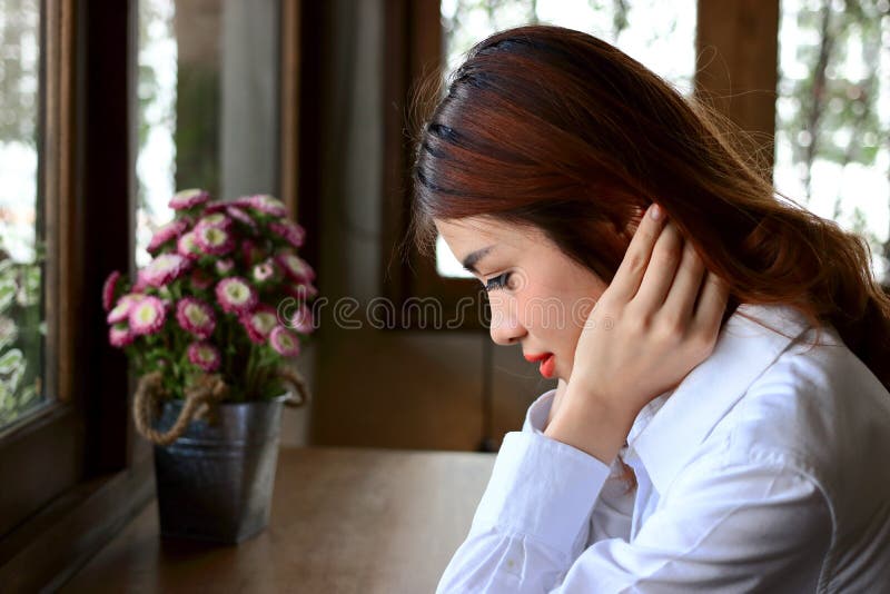 Side view of young attractive Asian business woman sitting in coffee cafe. royalty free stock photography Side view of young attractive Asian business woman sitting in coffee cafe. royalty free stock photography