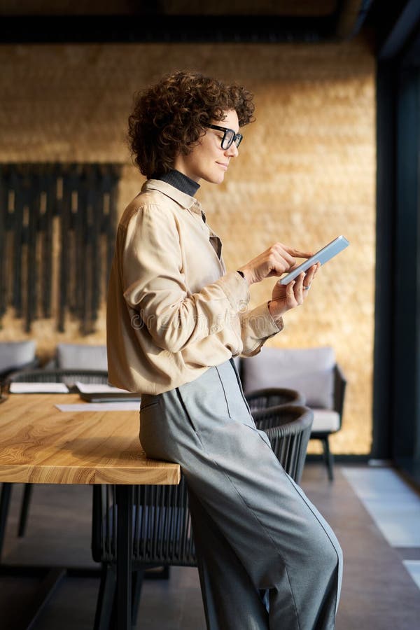 Side view of young confident female analyst pointing at tablet screen royalty free stock photography