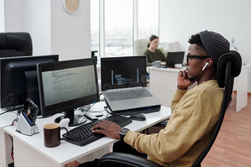 Side view of young serious lack man concentrating on decoding data in office royalty free stock photos