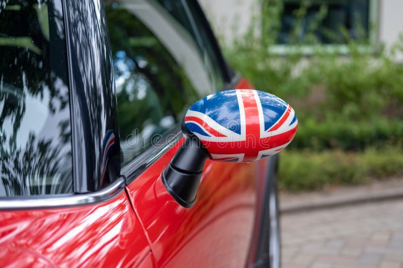 Side Window Showing Uk Flag on Red Car with Tinted Windows Stock Photo