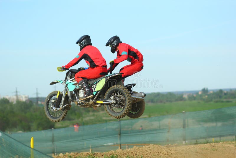 Sidecarmotocrossidrottsman nen som hoppar i luften arkivbild Sidecarmotocrossidrottsman nen som hoppar i luften arkivbild