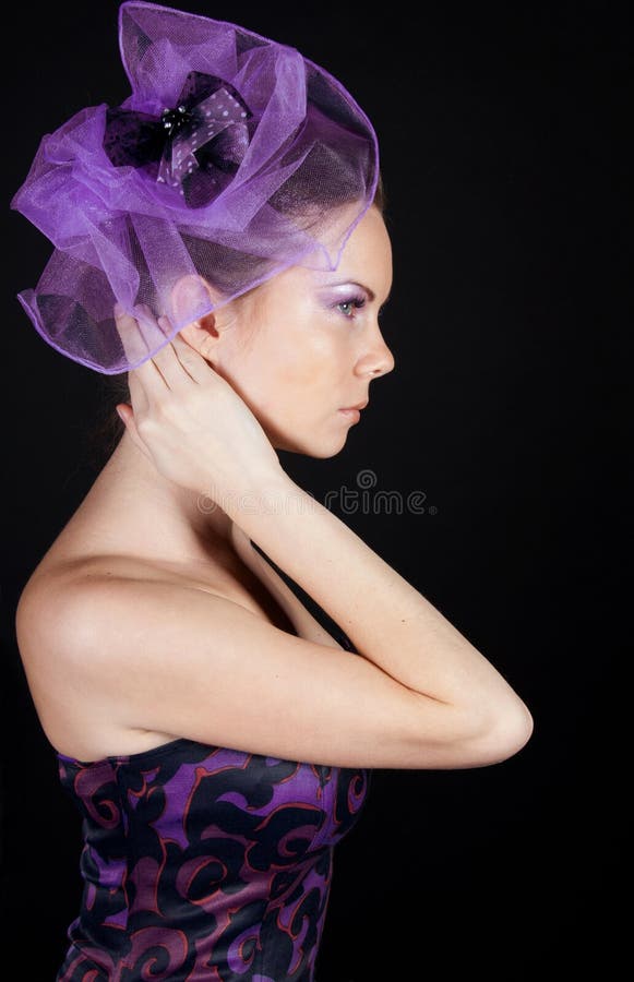 Sideview of beautiful young woman in violet hat