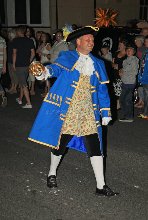 SIDMOUTH, DEVON, ANGLETERRE - 10 AOÛT 2012 : Le crieur public mène le cortège fermant de bas de nuit le long de l'esplanade E photos stock SIDMOUTH, DEVON, ANGLETERRE - 10 AOÛT 2012 : Le crieur public mène le cortège fermant de bas de nuit le long de l'esplanade E photos stock