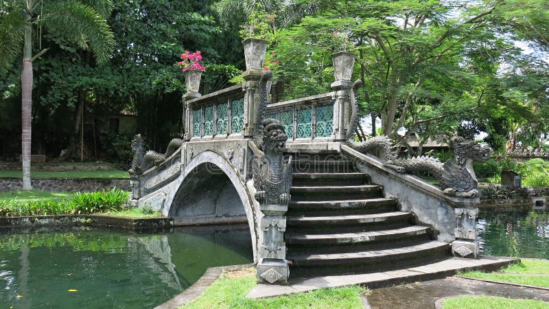Siersteenbrug over waterkanaal in koninklijke tuin De historische bouw met elementen van Balinese cultuur royalty-vrije stock afbeelding Siersteenbrug over waterkanaal in koninklijke tuin De historische bouw met elementen van Balinese cultuur royalty-vrije stock afbeelding