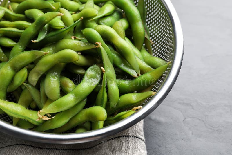 Sieve with Green Edamame Beans in Pods on Table, Closeup Stock Image