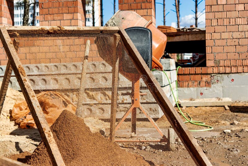Sifting Sand for Mortar at the Construction Site. Purification of Sand