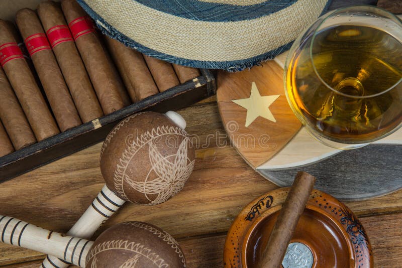 Cuban cigars and Rum or other alcohol in glass on table top view with vintage wooden background. Cuban cigars and Rum or other alcohol in glass on table top view with vintage wooden background