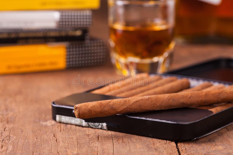 Cigars with whisky on old wooden table. Cigars with whisky on old wooden table