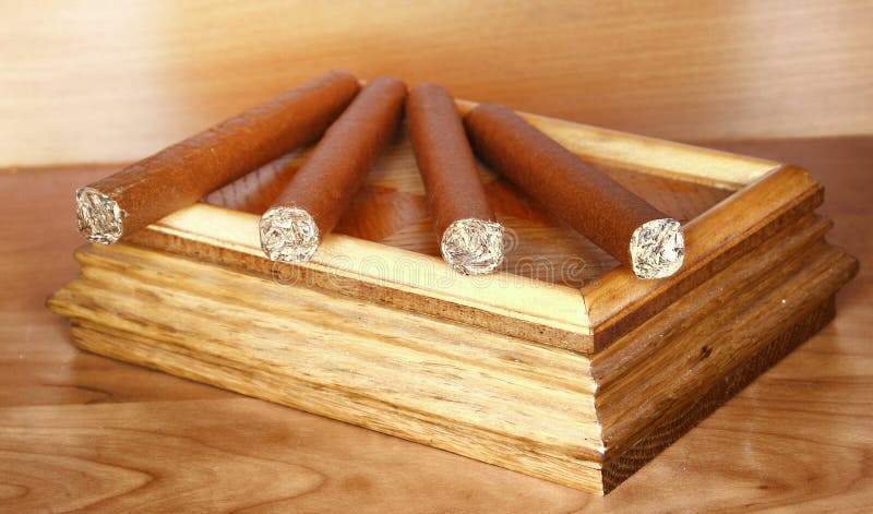 Cigars on top of wooden tobacco box. Cigars on top of wooden tobacco box