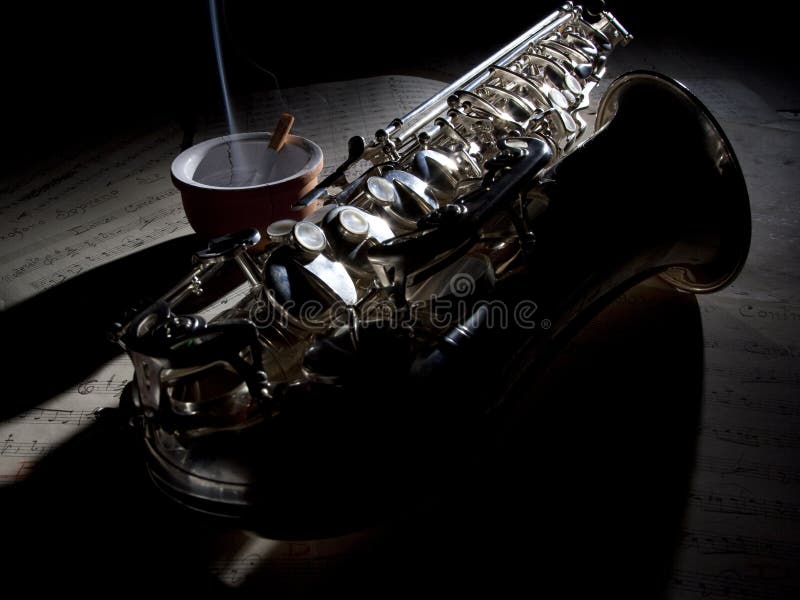 Sigaretta del sassofono e vecchia musica di strato fotografia stock libera da diritti Sigaretta del sassofono e vecchia musica di strato fotografia stock libera da diritti