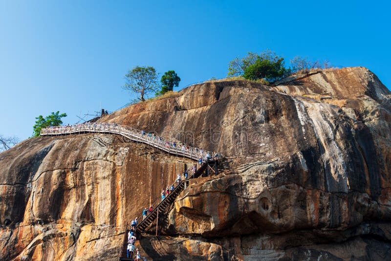 Sigiriya Sri Lanka - mars 31, 2019: Sigiriya vaggar det forntida lejonet f?stningen i Sri Lanka med turister fotografering för bildbyråer Sigiriya Sri Lanka - mars 31, 2019: Sigiriya vaggar det forntida lejonet f?stningen i Sri Lanka med turister fotografering för bildbyråer