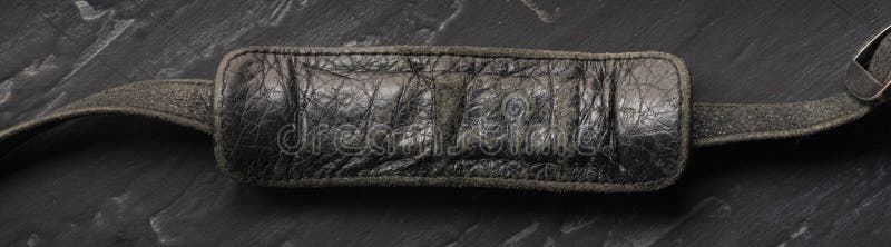 Sign, blank for text, place for inscription, copy space-leather black old worn handle from the bag on the strap close-up on a