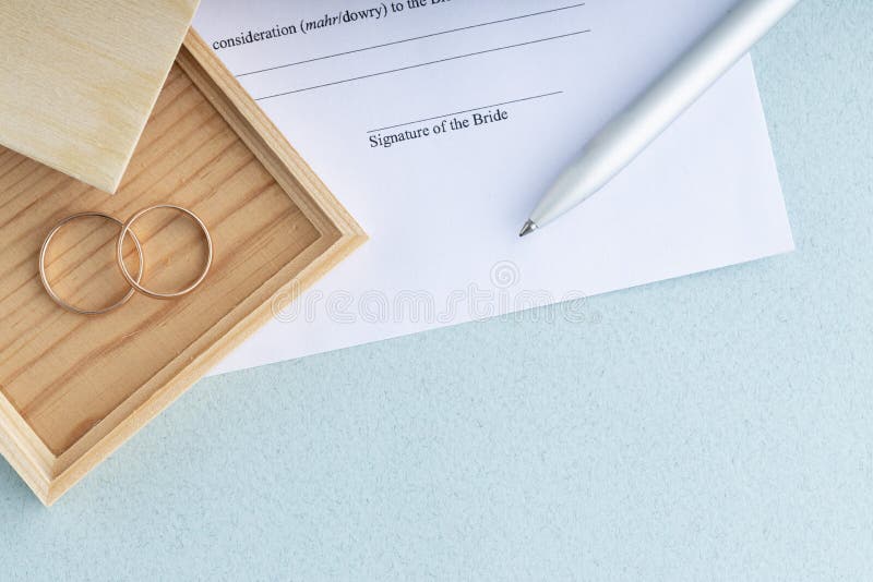 Sign of Marriage Contract Form Agreement with a Pair of Wedding Rings