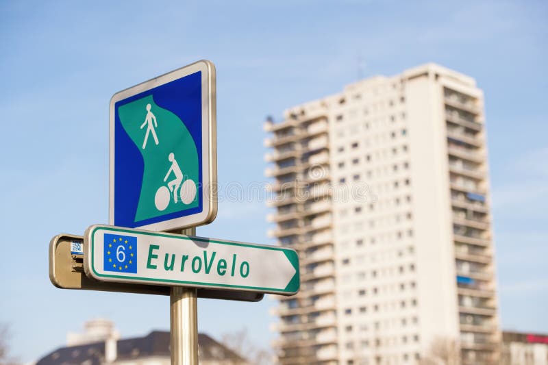 Mulhouse, France - Dec 19, 2015: Signage of the bike route EuroVelo 6 stage in Alsace leads via the Ill Valley to the town of Illfurth. Apartment building in background