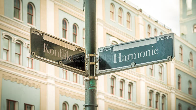 An image with a signpost pointing in two different directions in German. One direction points to harmony, the other points to conflict. An image with a signpost pointing in two different directions in German. One direction points to harmony, the other points to conflict