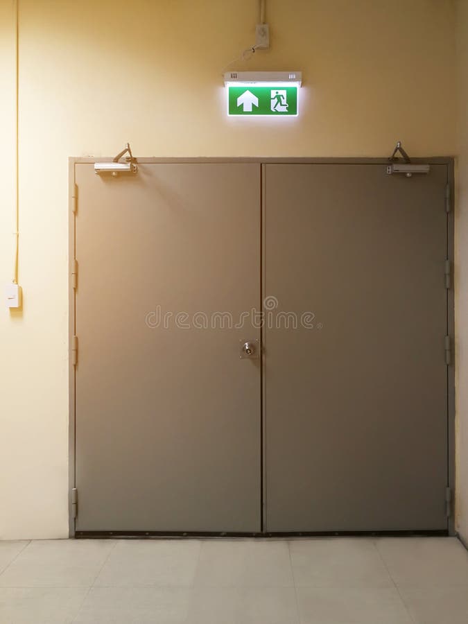 signe vert de sortie de secours d'installer au-dessus de la construction de bâtiments de porte montrant la manière de s'échapper image stock signe vert de sortie de secours d'installer au-dessus de la construction de bâtiments de porte montrant la manière de s'échapper image stock