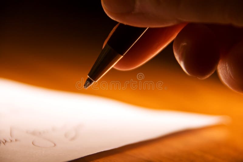 Una visione ravvicinata delle dita di una mano che tiene una penna a inchiostro, in procinto di firmare un contratto.