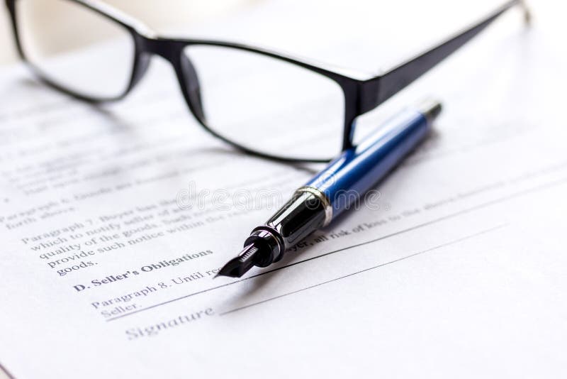 Signing the contract with pen and glasses in business work on office desk stock images