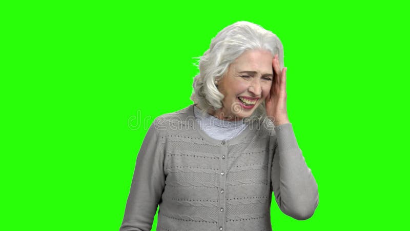 Signora anziana allegra sta ridendo sullo schermo verde