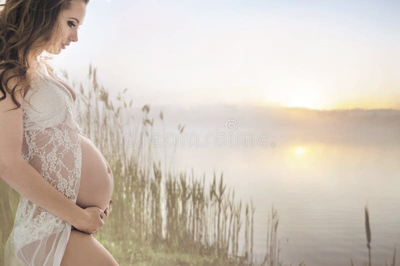 Signora incinta calma che si rilassa dal lago