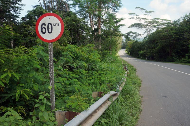 Red Round 60km h Speed Limit Sign On Highway In Front Of Blue Sky Stock red-round-60km-h-speed-limit-sign-on-highway-in-front-of-blue-sky-stock