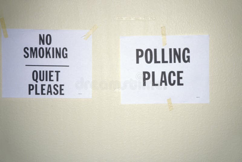 Signs taped to the wall in a polling place read No Smoking and Polling Place