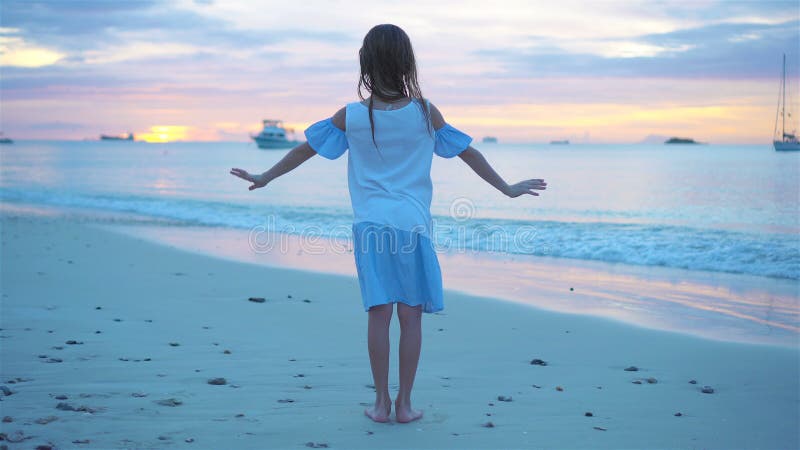 Sihouette de la danse de petite fille sur la plage au coucher du soleil clips vidéos