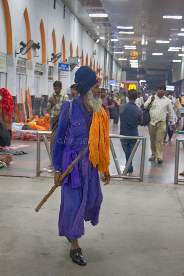 India, Delhi - March 19, 2018: Indian Sikhs as railway passengers in traditional blue clothes: lungi, broad pants, shirts, vests, turban pagri, symbolic spear nihang warriors, do`t cut hair. India, Delhi - March 19, 2018: Indian Sikhs as railway passengers in traditional blue clothes: lungi, broad pants, shirts, vests, turban pagri, symbolic spear nihang warriors, do`t cut hair