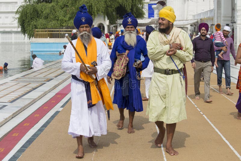 AMRITSAR, INDIA - SEPTEMBER 26, 2014: Unidentified Sikhs and indian people visiting the Golden Temple in Amritsar, Punjab, India. Sikh pilgrims travel from all over India to pray at this holy site. AMRITSAR, INDIA - SEPTEMBER 26, 2014: Unidentified Sikhs and indian people visiting the Golden Temple in Amritsar, Punjab, India. Sikh pilgrims travel from all over India to pray at this holy site