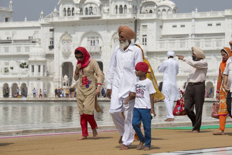 AMRITSAR, INDIA - SEPTEMBER 26, 2014: Unidentified Sikhs and indian people visiting the Golden Temple in Amritsar, Punjab, India. Sikh pilgrims travel from all over India to pray at this holy site. AMRITSAR, INDIA - SEPTEMBER 26, 2014: Unidentified Sikhs and indian people visiting the Golden Temple in Amritsar, Punjab, India. Sikh pilgrims travel from all over India to pray at this holy site