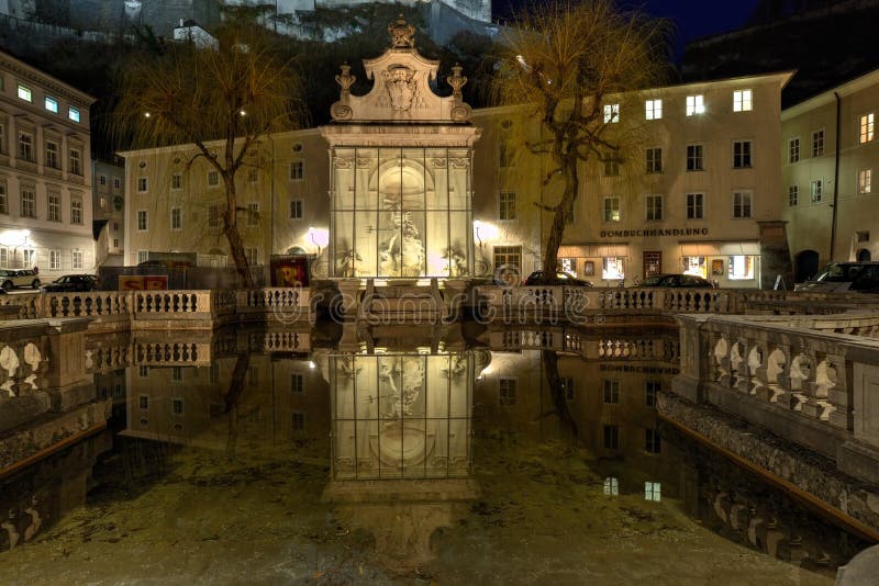Sikt av den gamla hästen väl på den Kapitelplatz fyrkanten på natten Salzburg lägre Österrike fotografering för bildbyråer Sikt av den gamla hästen väl på den Kapitelplatz fyrkanten på natten Salzburg lägre Österrike fotografering för bildbyråer