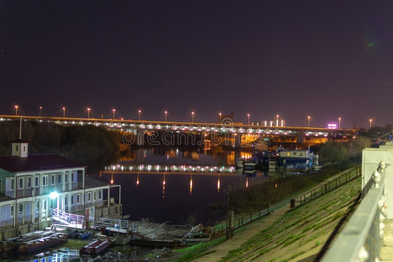 Sikt av nattstaden på flodbanken Sikt av tunnelbanabron i Nizhny Novgorod Reflexion av träd i floden Oka royaltyfri fotografi Sikt av nattstaden på flodbanken Sikt av tunnelbanabron i Nizhny Novgorod Reflexion av träd i floden Oka royaltyfri fotografi