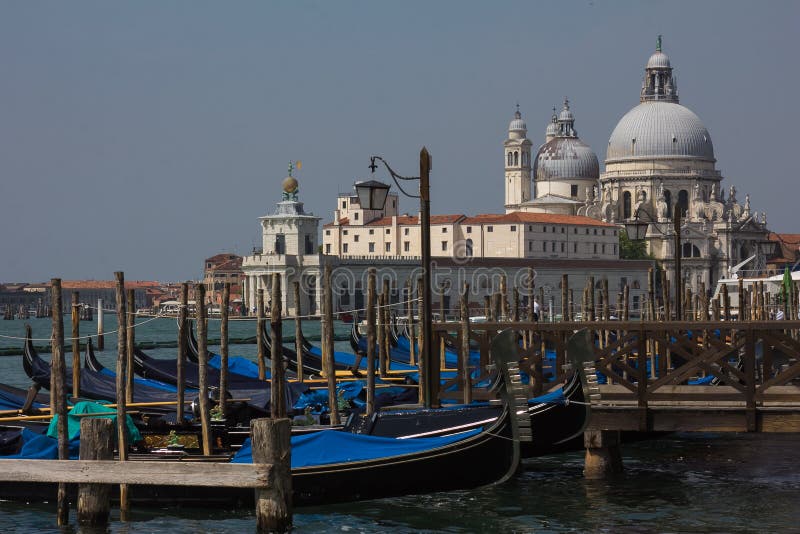 Sikt av traditionella gondoler på kanalen som är stor med historiska basilikadi Santa Maria della Salute royaltyfri fotografi Sikt av traditionella gondoler på kanalen som är stor med historiska basilikadi Santa Maria della Salute royaltyfri fotografi