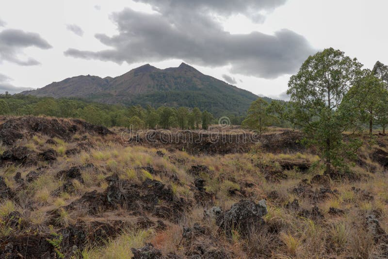 Sikt av överkanten av den aktiva Batur vulkan på den Bali ön i Indonesien Majestätiskt berg med moln över maximumet Lava Stones royaltyfri bild Sikt av överkanten av den aktiva Batur vulkan på den Bali ön i Indonesien Majestätiskt berg med moln över maximumet Lava Stones royaltyfri bild
