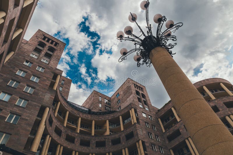 Sikt från botten som ska överträffas av den monumentala runda byggnaden, gataljuset och den molniga himlen, Yerevan royaltyfri fotografi Sikt från botten som ska överträffas av den monumentala runda byggnaden, gataljuset och den molniga himlen, Yerevan royaltyfri fotografi
