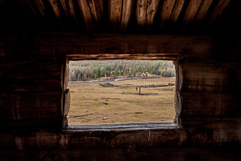 Sikt från det lilla fönstret för journal till fältet med en lantgård och en flod arkivfoton Sikt från det lilla fönstret för journal till fältet med en lantgård och en flod arkivfoton