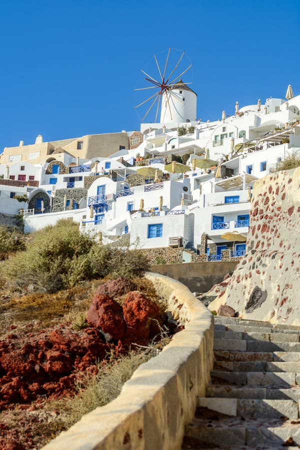 Sikt på den vita väderkvarnen och traditionell arkitektur av den Oia staden på den Santorini ön royaltyfria bilder Sikt på den vita väderkvarnen och traditionell arkitektur av den Oia staden på den Santorini ön royaltyfria bilder