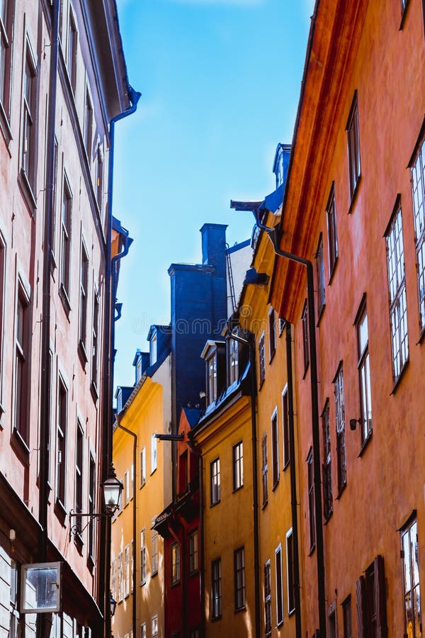 Sikt underifrån på den hemtrevliga smala medeltida gatan med förbindelsegula orange röda byggnadsfasader i stan Gamla, gammal arkivfoto Sikt underifrån på den hemtrevliga smala medeltida gatan med förbindelsegula orange röda byggnadsfasader i stan Gamla, gammal arkivfoto