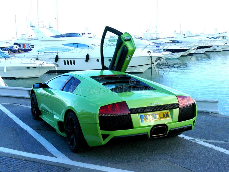 Sikten för den bakre sidan av en gräsplanLamborghini kupé som parkeras på kustlinjen seglar tillsammans med arkivbilder Sikten för den bakre sidan av en gräsplanLamborghini kupé som parkeras på kustlinjen seglar tillsammans med arkivbilder