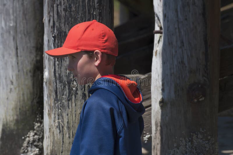 Close up of a young boy wearing an orange ball cap next to a pier in Siletz Pay Park in Lincoln City Oregon. Close up of a young boy wearing an orange ball cap next to a pier in Siletz Pay Park in Lincoln City Oregon