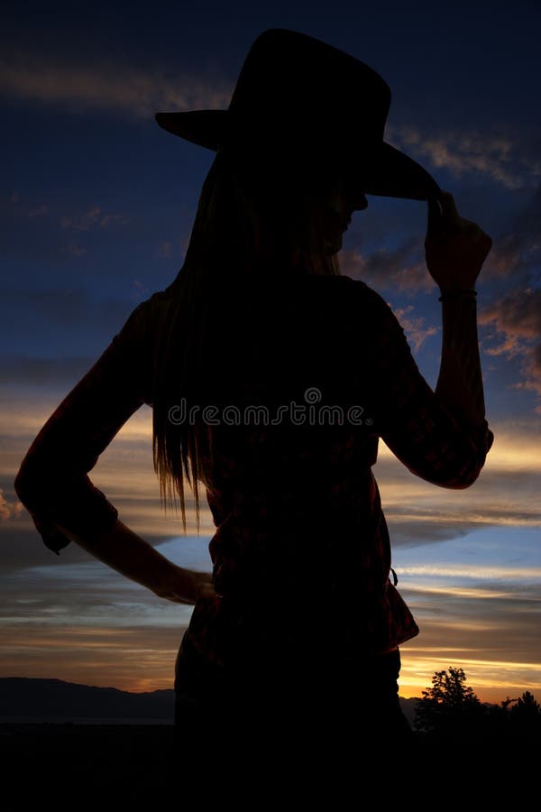 Silhouet die van veedrijfster haar hoed tippen bij zonsondergang royalty-vrije stock foto's Silhouet die van veedrijfster haar hoed tippen bij zonsondergang royalty-vrije stock foto's