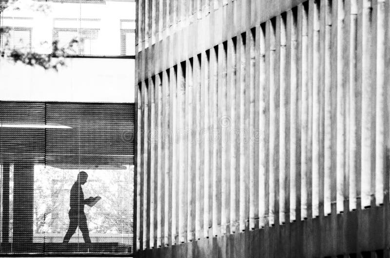 Silhouet van een mens die een krant in de architectuur van de stad lezen royalty-vrije stock foto's Silhouet van een mens die een krant in de architectuur van de stad lezen royalty-vrije stock foto's
