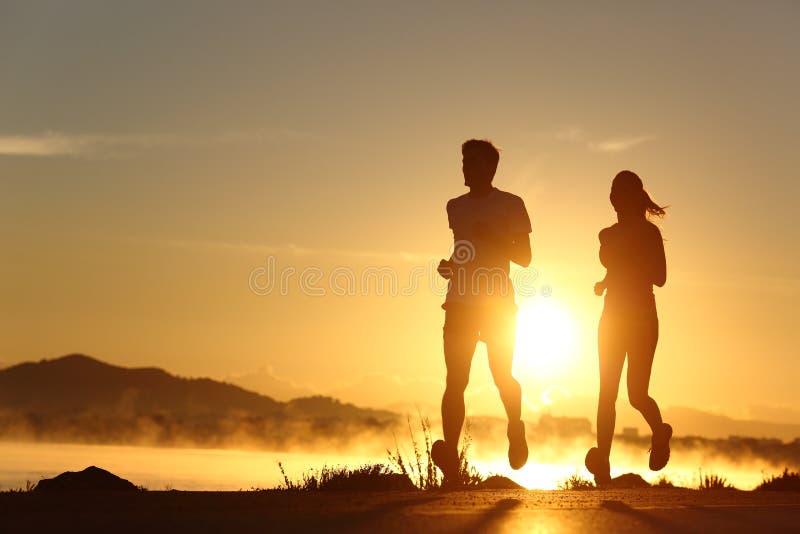 Silhouet van een paar die bij zonsondergang lopen royalty-vrije stock foto's Silhouet van een paar die bij zonsondergang lopen royalty-vrije stock foto's