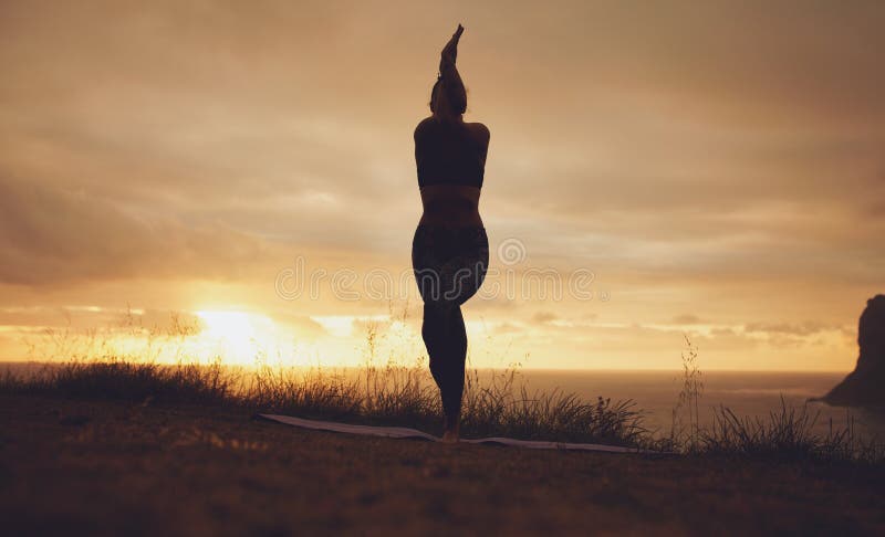 Silhouet van een vrouw het praktizeren yoga, Garudasana royalty-vrije stock fotografie Silhouet van een vrouw het praktizeren yoga, Garudasana royalty-vrije stock fotografie