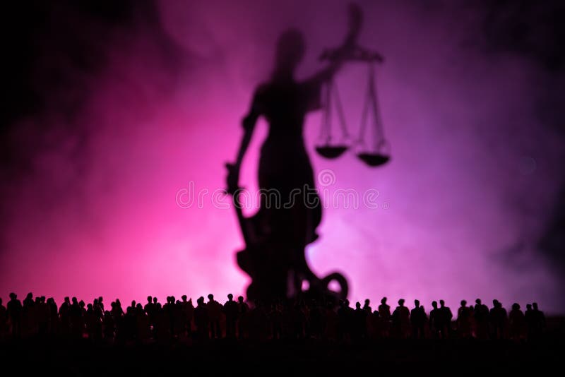 Silhouet van het vage reuzestandbeeld van de damerechtvaardigheid met zwaard en schaal die zich achter menigte bij nacht met mist royalty-vrije stock foto's Silhouet van het vage reuzestandbeeld van de damerechtvaardigheid met zwaard en schaal die zich achter menigte bij nacht met mist royalty-vrije stock foto's