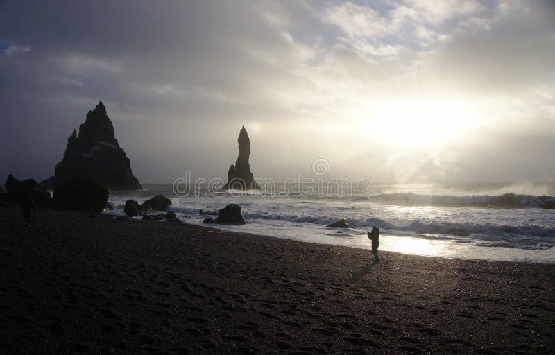 Silhouet voor golven op de kust van zwart zandstrand, IJsland stock foto Silhouet voor golven op de kust van zwart zandstrand, IJsland stock foto