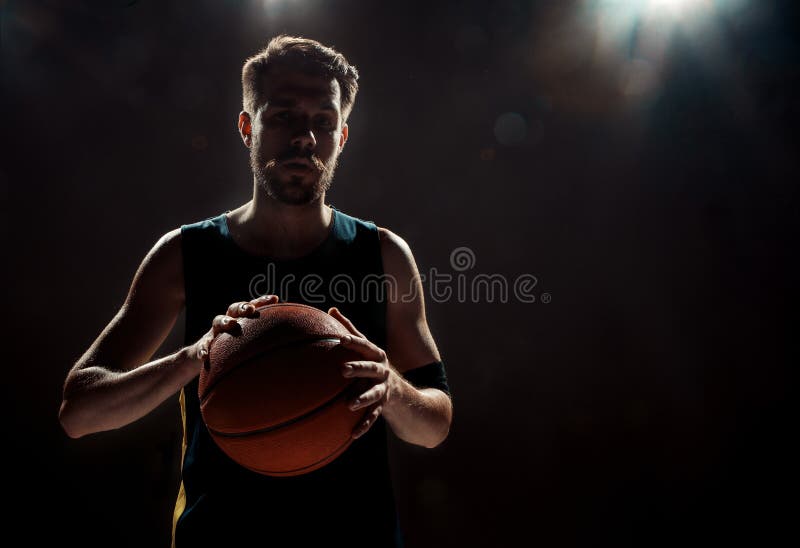 Silhouetmening van een bal van de de holdingsmand van de basketbalspeler op zwarte achtergrond stock foto's Silhouetmening van een bal van de de holdingsmand van de basketbalspeler op zwarte achtergrond stock foto's
