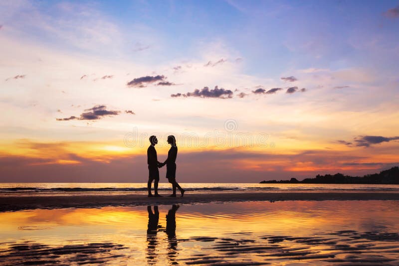 Silhouette of afectionate couple on the beach at sunset stock image Silhouette of afectionate couple on the beach at sunset stock image