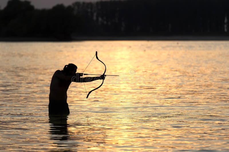 Silhouette Archery Shoots a Bow at a Target in Sunset Sky Stock Image